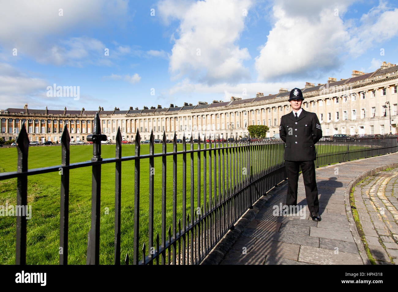 Un poliziotto inglese, Bobby o rame, in piedi Royal Crescent a Bath in Inghilterra. Egli indossa una tunica di formale e custode casco Foto Stock