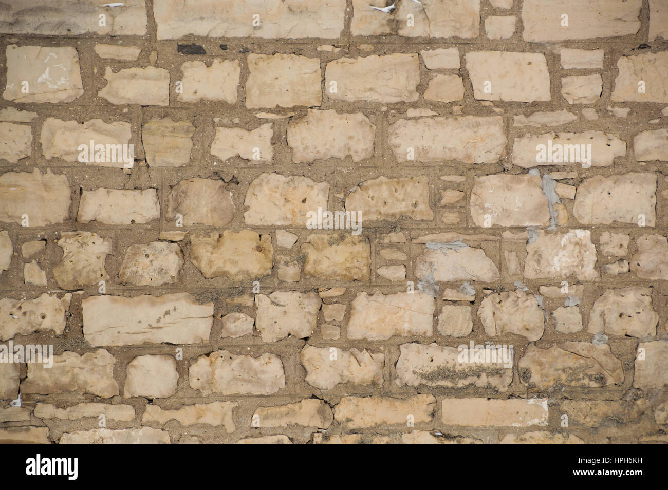 Robusto vecchio muro di pietra calcarea che è irregolare, rustico e riempite con malta cementizia. Foto Stock