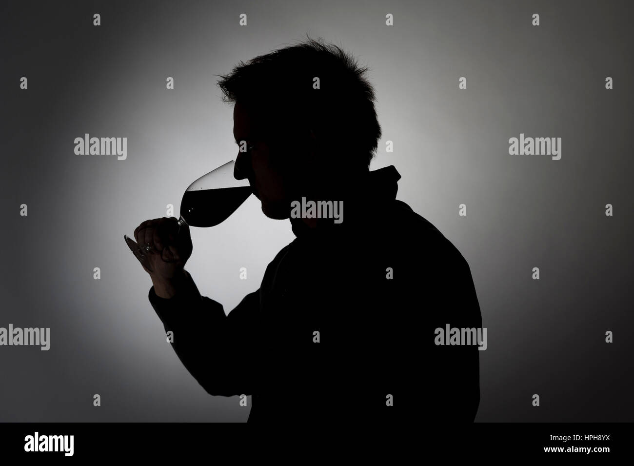 Mann trinkt aus Weinglas, Silhouette - uomo beve vino, Modello rilasciato Foto Stock