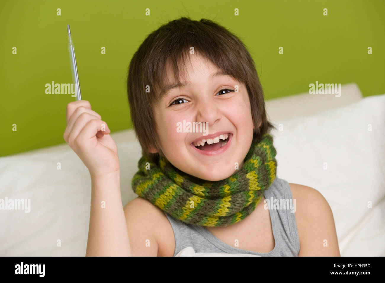 Junge Froehlicher mit Fieberthermometer in der mano hat kein Fieber mehr - little boy è nuovamente helath, Modello rilasciato Foto Stock