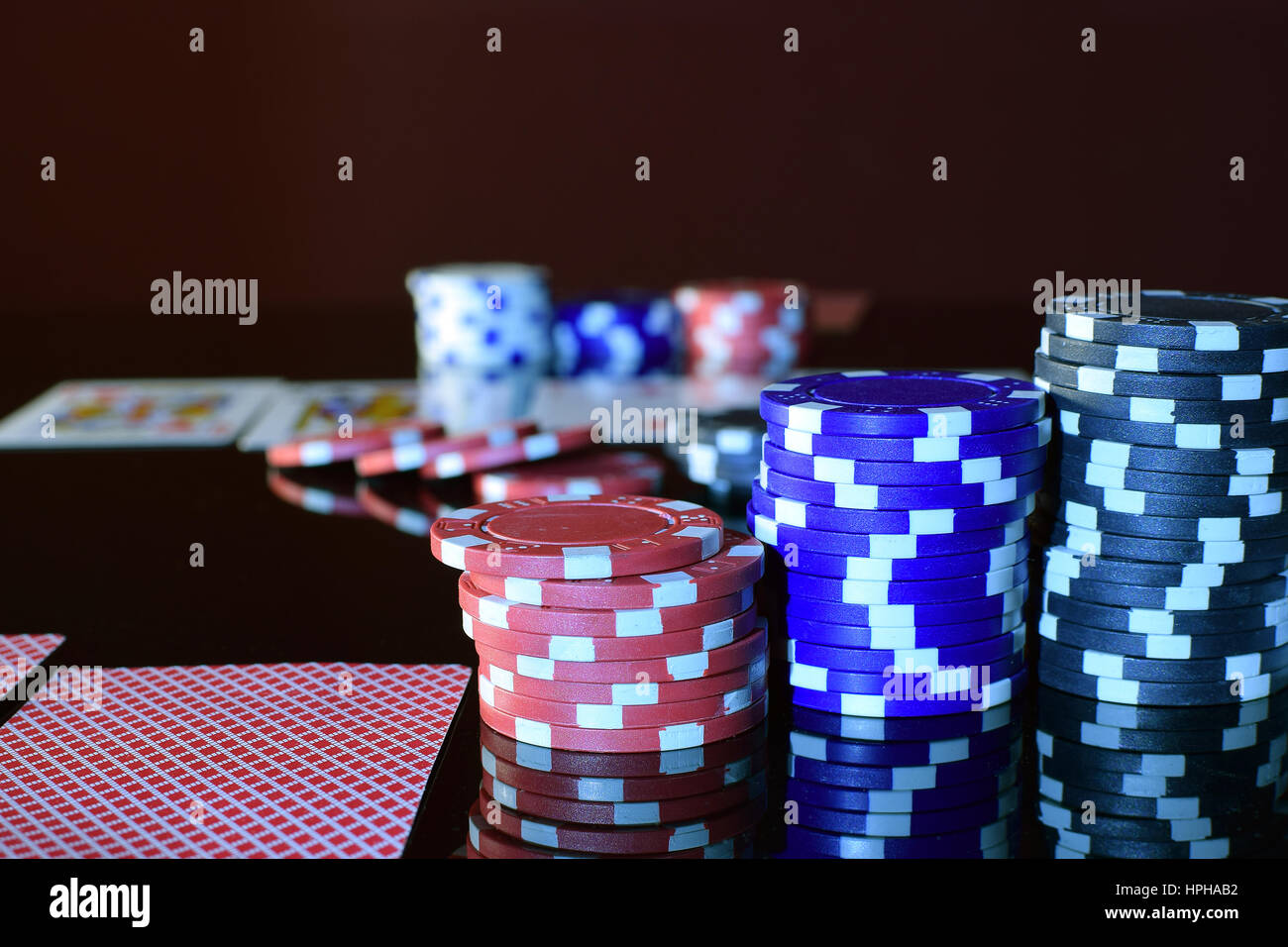 Fiches di poker colorati e carte da gioco disposte sul tavolo da gioco Foto  stock - Alamy