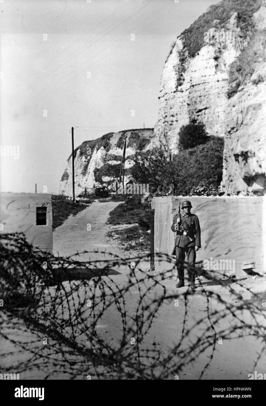 L'immagine della propaganda nazista mostra una sentinella tedesca di Wehrmacht ad un bunker sul Muro Atlantico. Pubblicato nel giugno 1943. Un reporter nazista ha scritto sul retro dell'immagine su 05.06.1943 'sul Muro Atlantico. In molti luoghi, le scogliere si innalzano sopra la costa, fornendo protezione naturale e, insieme agli ostacoli che sono stati posti, rendono impossibile un'invasione." Fotoarchiv für Zeitgeschichte - NESSUN SERVIZIO WIRELESS - | utilizzo in tutto il mondo Foto Stock