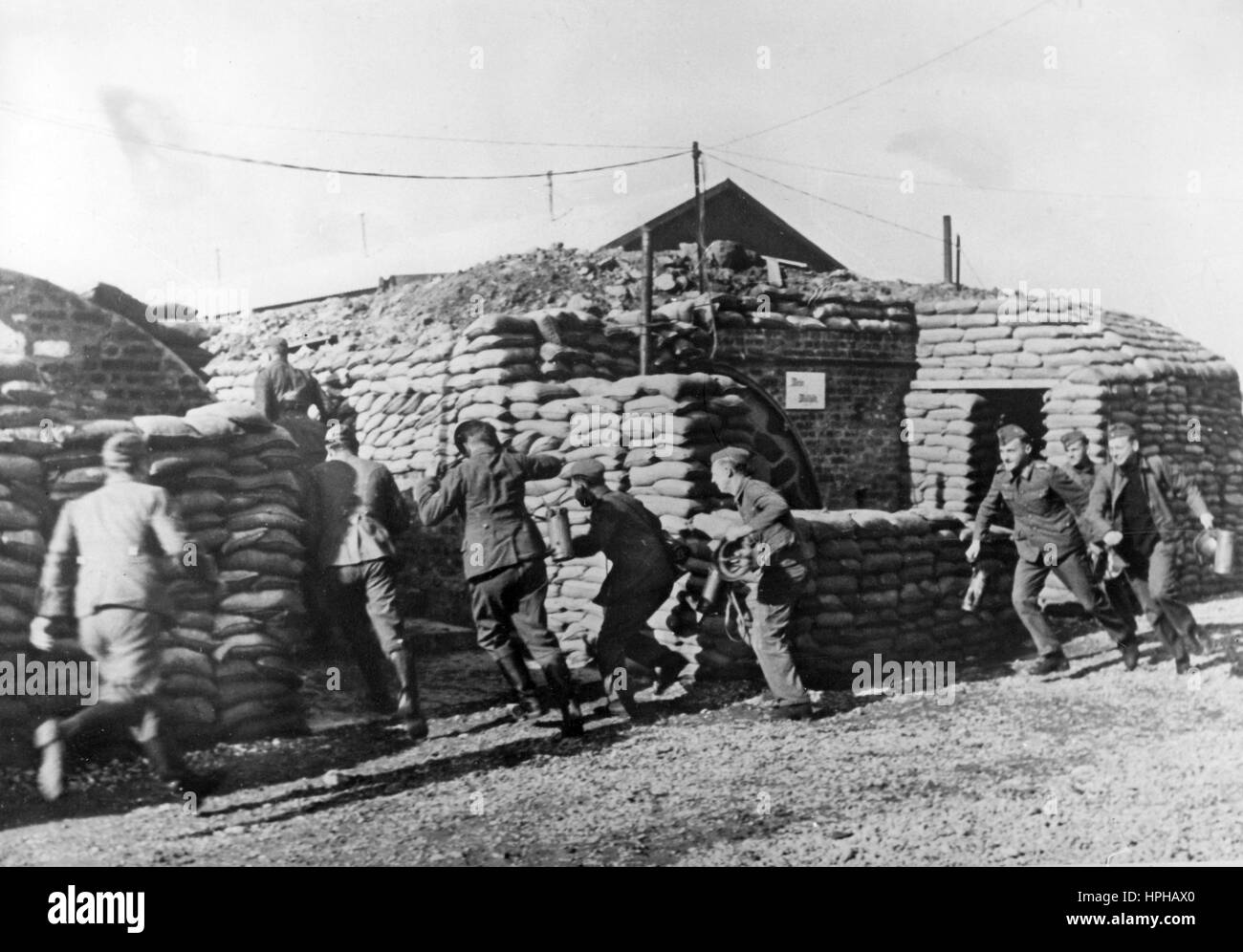 L'immagine della propaganda nazista mostra i soldati di un'unità di artiglieria tedesca Wehrmacht durante un allarme, sulla loro strada verso le armi in una base sulla costa della Manica nella Francia occupata, pubblicato nel febbraio 1941. Un reporter nazista ha scritto sul retro della foto su 09.02.1941, 'fuoco sul convoglio nemico! Convoglio inglese avvistato presso la nostra artiglieria più pesante sulla costa del canale. "Allarme!" Il grido riecheggia attraverso la batteria. Dai dugouts accuratamente sigillati, la squadra storms alle pistole." Fotoarchiv für Zeitgeschichte - NESSUN SERVIZIO DI CABLAGGIO - | utilizzo in tutto il mondo Foto Stock