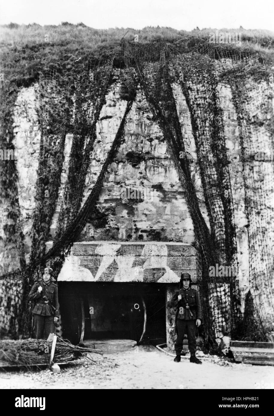 L'immagine della propaganda nazista mostra una sentinella tedesca di Wehrmacht ad un bunker armato sul lato francese della costa del canale. Pubblicato nel dicembre 1943. Un reporter nazista ha scritto sul retro della foto su 28.12.1943, 'pronto a difendere sulla costa del canale. Le enormi fortificazioni e il Muro Atlantico sono al più alto livello possibile di difesa di riserva. La nostra immagine mostra una batteria integrata in una scogliera". Fotoarchiv für Zeitgeschichte - NESSUN SERVIZIO WIRELESS - | utilizzo in tutto il mondo Foto Stock L'immagine della propaganda nazista mostra una sentinella tedesca di Wehrmacht ad un bunker armato sul lato francese della costa del canale. Pubblicato nel dicembre 1943. Un reporter nazista ha scritto sul retro della foto su 28.12.1943, 'pronto a difendere sulla costa del canale. Le enormi fortificazioni e il Muro Atlantico sono al più alto livello possibile di difesa di riserva. La nostra immagine mostra una batteria integrata in una scogliera". Fotoarchiv für Zeitgeschichte - NESSUN SERVIZIO WIRELESS - | utilizzo in tutto il mondo Foto Stock