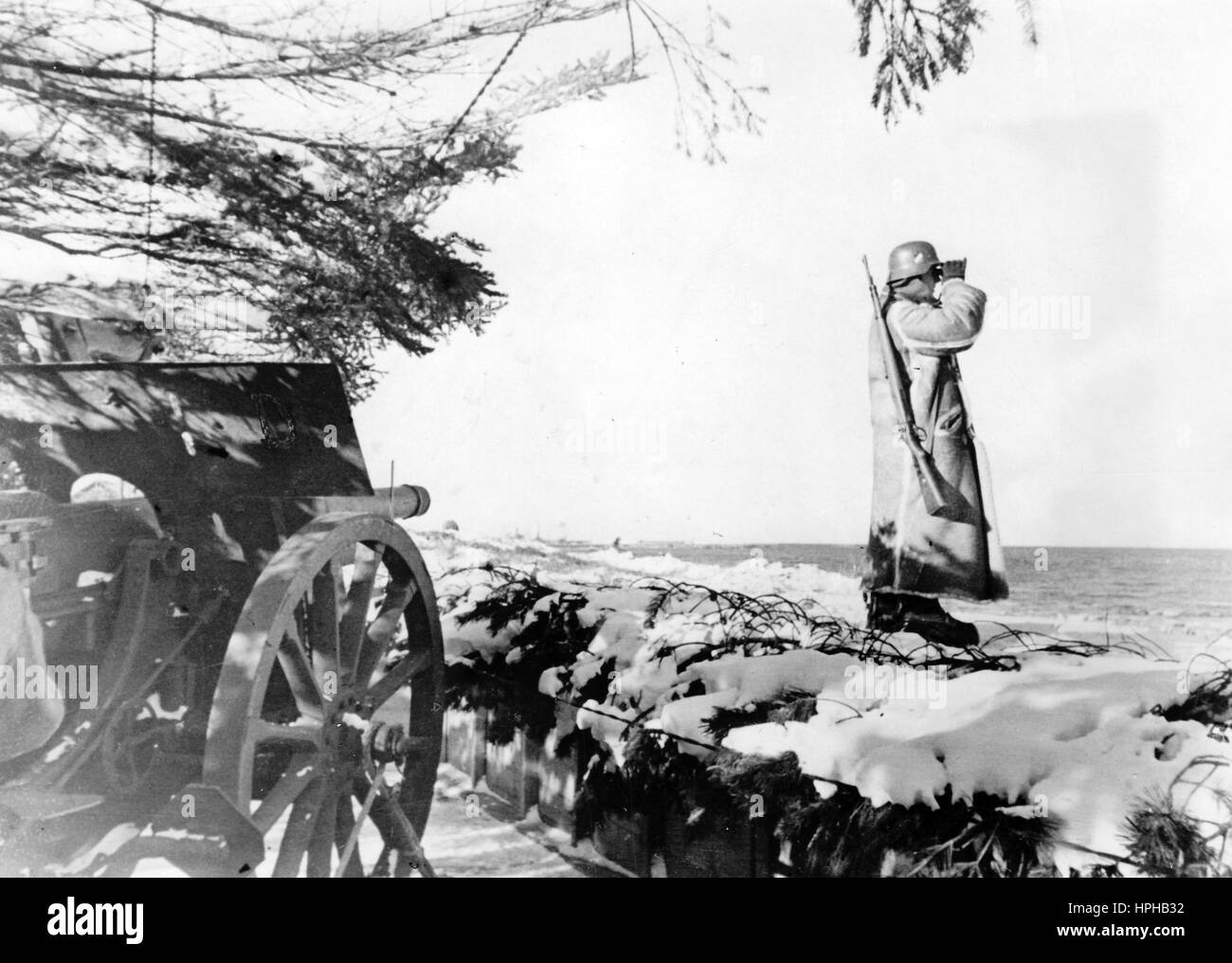 L'immagine della propaganda nazista mostra una sentinella tedesca di Wehrmacht sulla costa danese del Mare del Nord, in un bunker armato sul Muro Atlantico. Pubblicato nel marzo 1942. Un reporter nazista ha scritto sul retro della foto su 12.03.1942, 'guardie della costa in ghiaccio e neve. Ben mimetizzazione con l'aiuto di alberi di abete basso, artiglieria da spiaggia sulla costa settentrionale dello Jutland. Lasciate che un Tommy rischi solo di essere avvistato..." Fotoarchiv für Zeitgeschichte - NESSUN SERVIZIO WIRELESS - | utilizzo in tutto il mondo Foto Stock L'immagine della propaganda nazista mostra una sentinella tedesca di Wehrmacht sulla costa danese del Mare del Nord, in un bunker armato sul Muro Atlantico. Pubblicato nel marzo 1942. Un reporter nazista ha scritto sul retro della foto su 12.03.1942, 'guardie della costa in ghiaccio e neve. Ben mimetizzazione con l'aiuto di alberi di abete basso, artiglieria da spiaggia sulla costa settentrionale dello Jutland. Lasciate che un Tommy rischi solo di essere avvistato..." Fotoarchiv für Zeitgeschichte - NESSUN SERVIZIO WIRELESS - | utilizzo in tutto il mondo Foto Stock