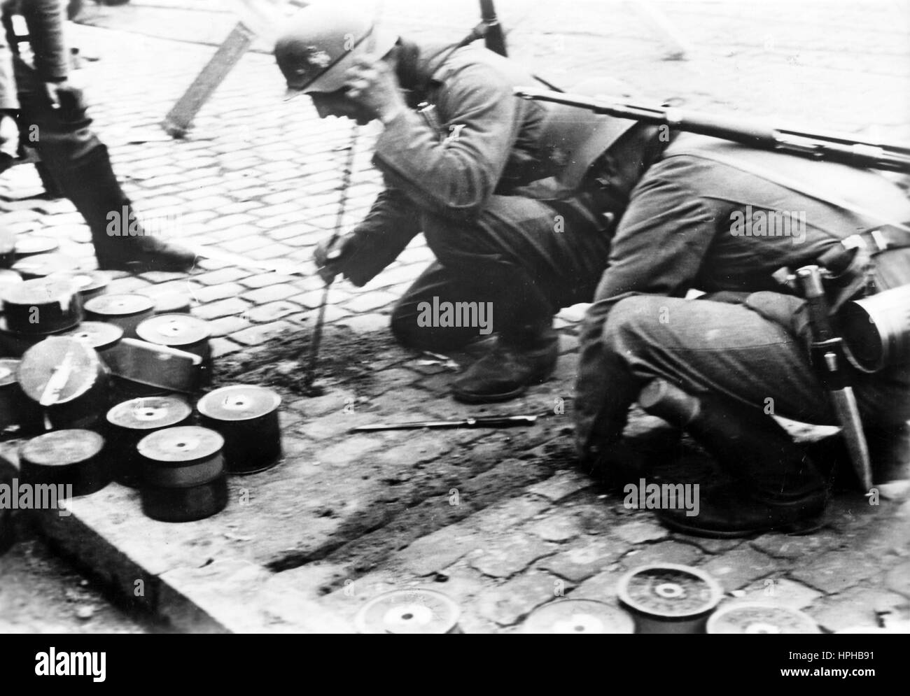 L'immagine della propaganda nazista mostra i soldati tedeschi della Wehrmacht che disattivano le mine nella Bruxelles occupata in Belgio. Presa nel maggio 1940. Un reporter di stato nazista ha scritto sul retro della foto su 20.05.1940, 'barriere minerari rese innocue. Tra i pericolosi ostacoli posti alle truppe tedesche dal nemico vi sono le barriere delle mine. La nostra foto mostra i soldati tedeschi che guardano sotto la pavimentazione delle strade di Bruxelles. Fotoarchiv für Zeitgeschichte - NESSUN SERVIZIO DI CABLAGGIO - | utilizzo in tutto il mondo Foto Stock
