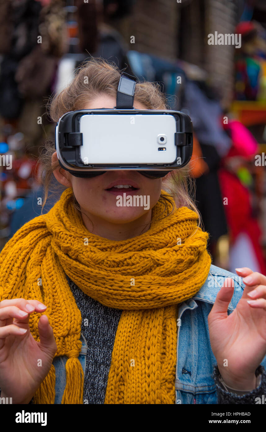Nuovi e innovativi per la Realtà Virtuale auricolare che viene testato da una giovane donna per le strade di Londra presso il mercato di Camden Foto Stock