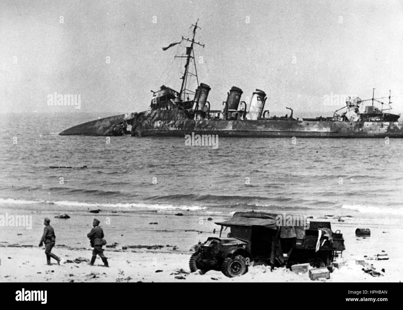 L'immagine della propaganda nazista mostra i soldati tedeschi della Wehrmacht di fronte a una nave da guerra britannica distrutta e alle auto militari sulla spiaggia di Ostenda occupata in Belgio. Pubblicato nel giugno 1940. Fotoarchiv für Zeitgeschichte - NON PER IL SERVIZIO DI CABLAGGIO - | utilizzo in tutto il mondo Foto Stock