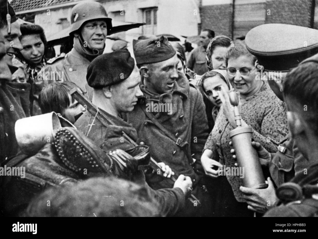 L'immagine della propaganda nazista mostra che soldati e civili belgi vengono 'intervistati' per la radio tedesca dopo l'occupazione del Belgio da parte della Wehrmacht tedesca. Pubblicato nel giugno 1940. Un reporter nazista ha scritto sul retro della foto su 27.06.1940, 'Broadcaster out and about in territorio nemico. Liberati dagli orrori degli ultimi giorni, soldati e civili belgi condividono le loro esperienze con l'emittente tedesca." Fotoarchiv für Zeitgeschichte - NON PER IL SERVIZIO DI CABLAGGIO - | utilizzo in tutto il mondo Foto Stock