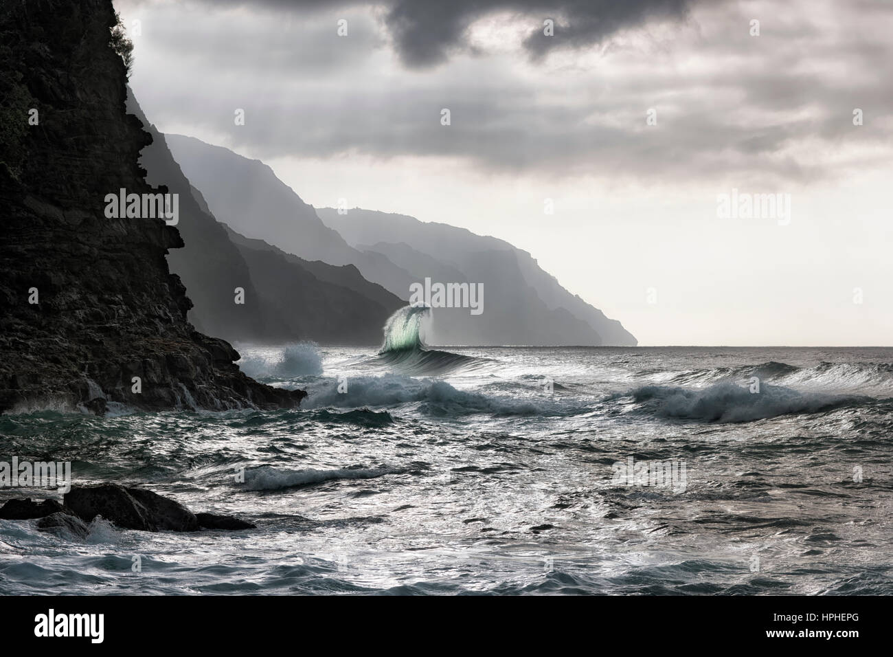 Inverno Condizioni surf creano grandi onde urtante vicino Kee spiaggia lungo la costa di Na Pali su Hawaii Isola di Kauai. Foto Stock