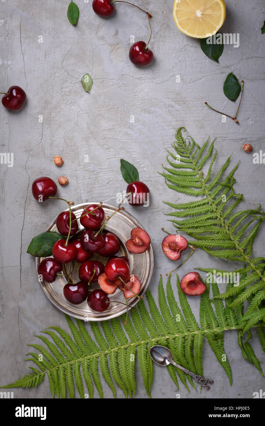 Dolce di ciliegie rosse su sfondo grigio. Vista superiore, copia dello spazio. Foto Stock