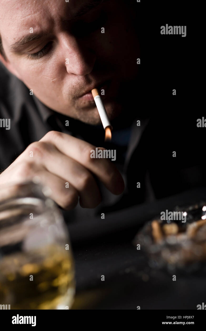 Modello rilasciato , Mann raucht sich eine Zigarette - un uomo fuma sigaretta Foto Stock