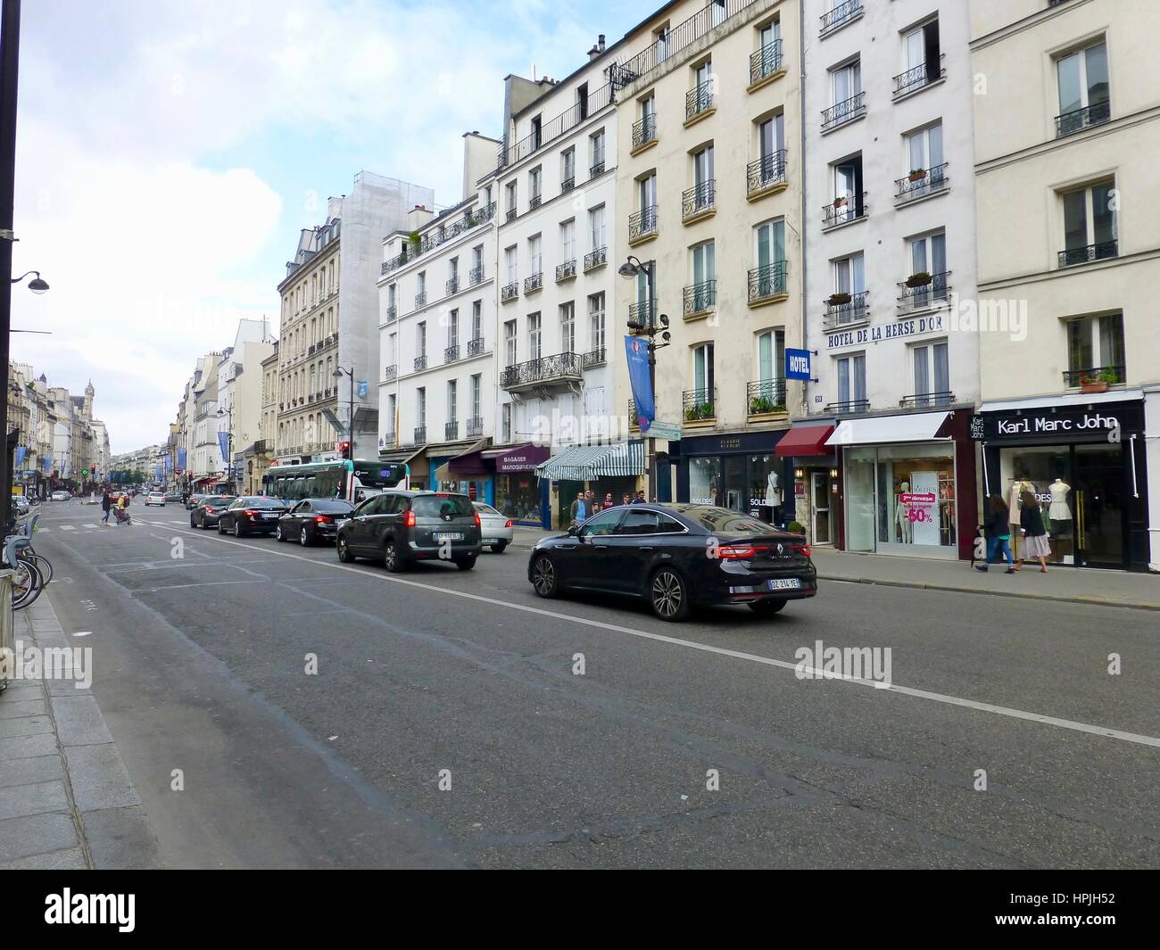 Shoppers esecuzione di commissioni su una Domenica mattina sul bordo del Marais. Rue Saint-Antoine, Parigi, Francia. Foto Stock