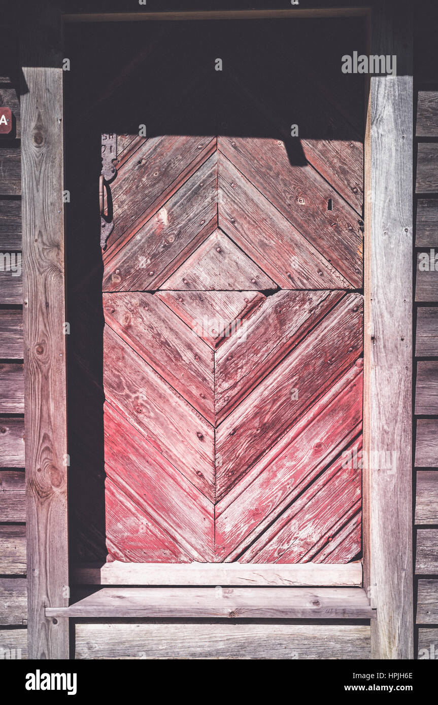 Un bellissimo vecchio rustico in legno fattoria rossa porta trovata in Norvegia. Foto Stock