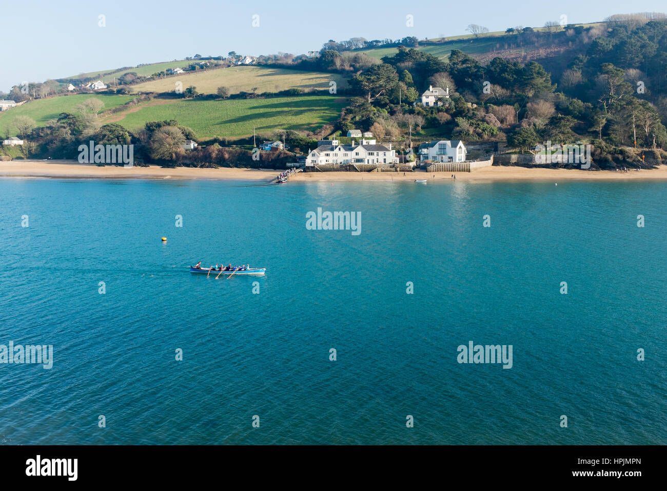 Gig essendo barca remi in Salcombe estuario in inverno Foto Stock