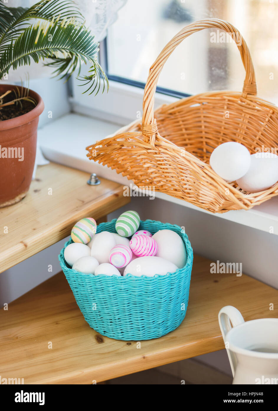 Cesto di pasqua con uova su un pavimento di legno Foto Stock