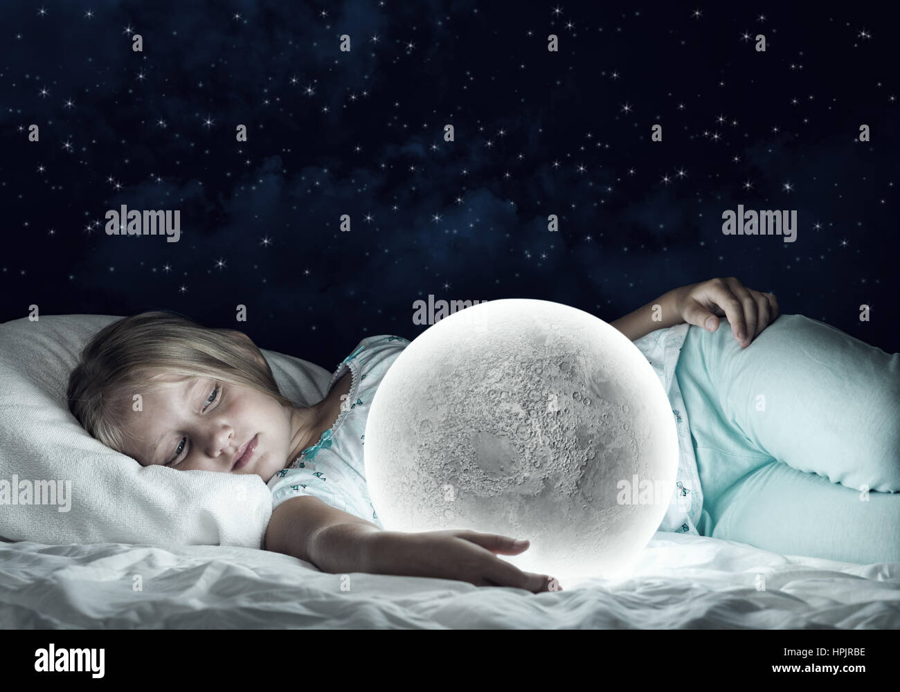 Ragazza nel suo letto luna e pianeta Foto Stock