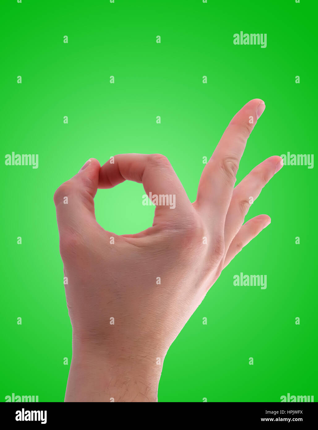 Segno ok con la mano su sfondo verde isolato Foto Stock