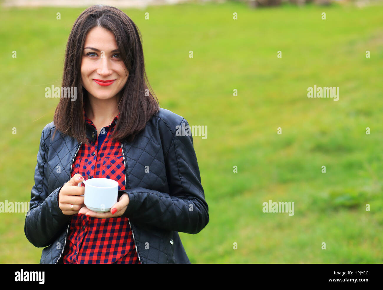 Ragazza sorridente con il bianco tazza di caffè al di fuori Foto Stock