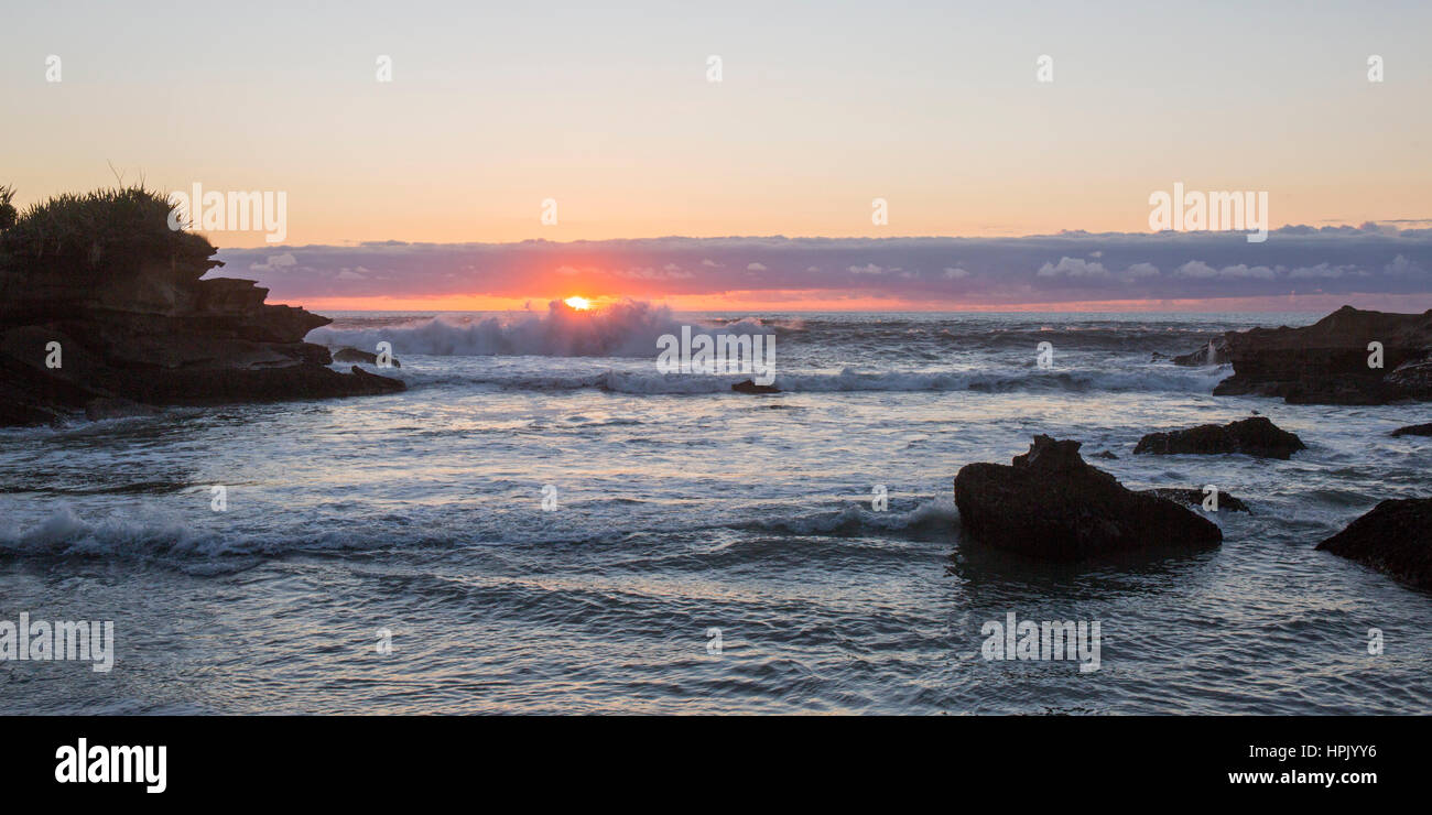 Punakaiki, Paparoa National Park, West Coast, Nuova Zelanda. Vista sul mare dalla baia isolata che segna la fine della pista di Truman, il tramonto. Foto Stock