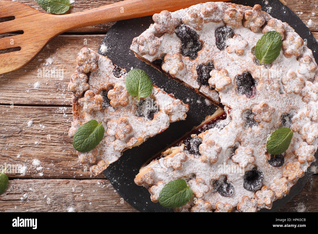 Torta dolce con marmellata di prugne e zucchero in polvere vicino sul tavolo. Vista orizzontale dal di sopra Foto Stock