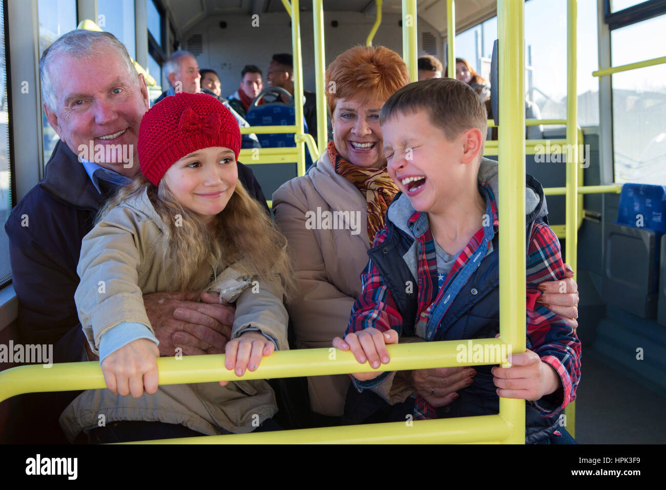 Nonni tenendo i loro nipoti fuori attraverso il bus. I bambini sono seduti sulle loro nonni le ginocchia. Foto Stock