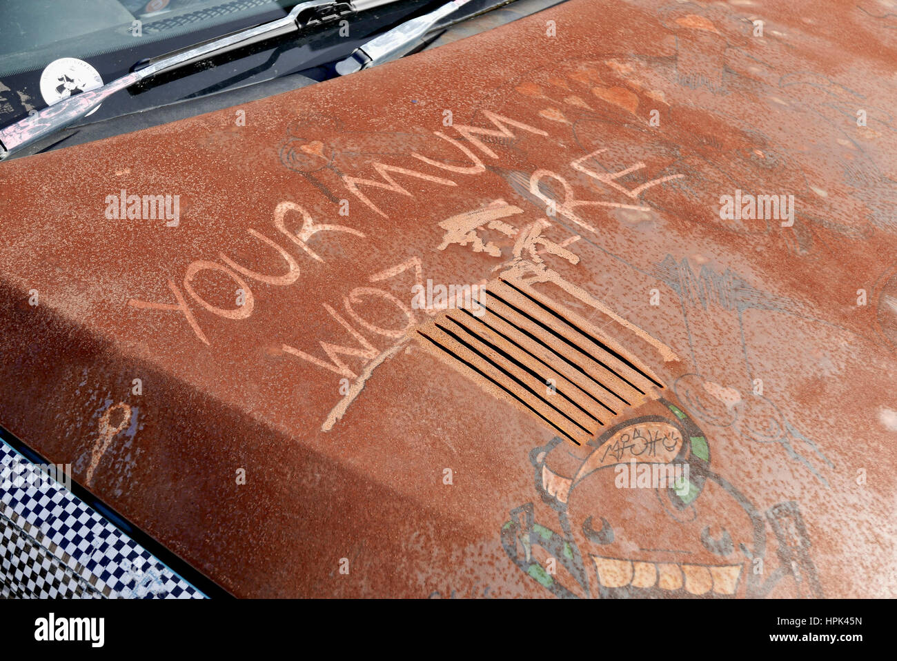 Opere d'arte graffiate sul cofano dell'auto arrugginito Foto Stock
