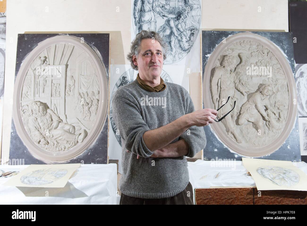 Ottendorf-Okrilla, Germania. Il 22 febbraio, 2017. Scultore Jan Kretzschmar è in piedi di fronte a due rilievi ovali della storica soffitto in stucco di Francoforte "scala d'Oro" presso il laboratorio di Fuchs e Gierke Bau und Denkmalpflege GmbH in Ottendorf-Okrilla, Germania, 22 febbraio 2017. La replica di 37 metri quadri, riccamente decorata con soffitti in stucco dal primo piano della Frankfurt casa in legno e muratura è stata realizzata da esperti di Sassonia. Il progetto ha un costo di circa 250.000 euro. Credito: dpa/Alamy Live News Foto Stock