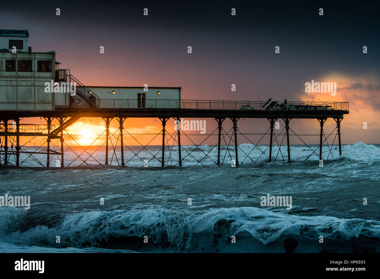 Aberystwyth, Wales, Regno Unito. 23 feb 2017. Regno Unito Meteo: uno spettacolare tramonto dietro il molo a Aberystwyth dopo il giorno-lomg assalto di Storm Storm Doris Doris era il quarto denominato storm dell'inverno ed è stato classificato come un "meteo bomba' (esplosiva cyclogenesis) dal Met Office Photo credit: Keith Morris/Alamy Live News Foto Stock