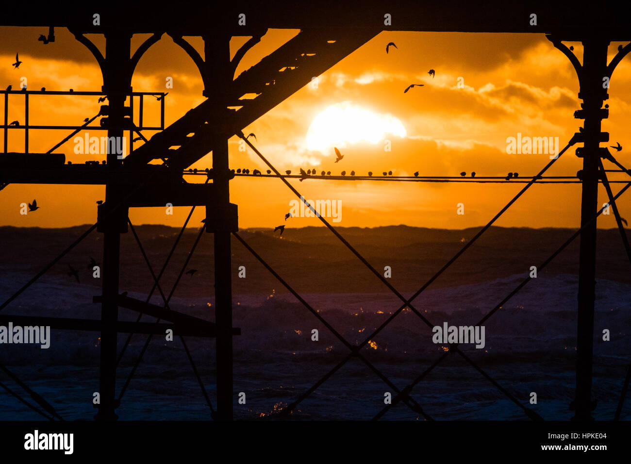 Aberystwyth, Wales, Regno Unito. 23 feb 2017. Regno Unito Meteo: uno spettacolare tramonto dietro il molo a Aberystwyth dopo il giorno-lomg assalto di Storm Storm Doris Doris era il quarto denominato storm dell'inverno ed è stato classificato come un "meteo bomba' (esplosiva cyclogenesis) dal Met Office Photo credit: Keith Morris/Alamy Live News Foto Stock