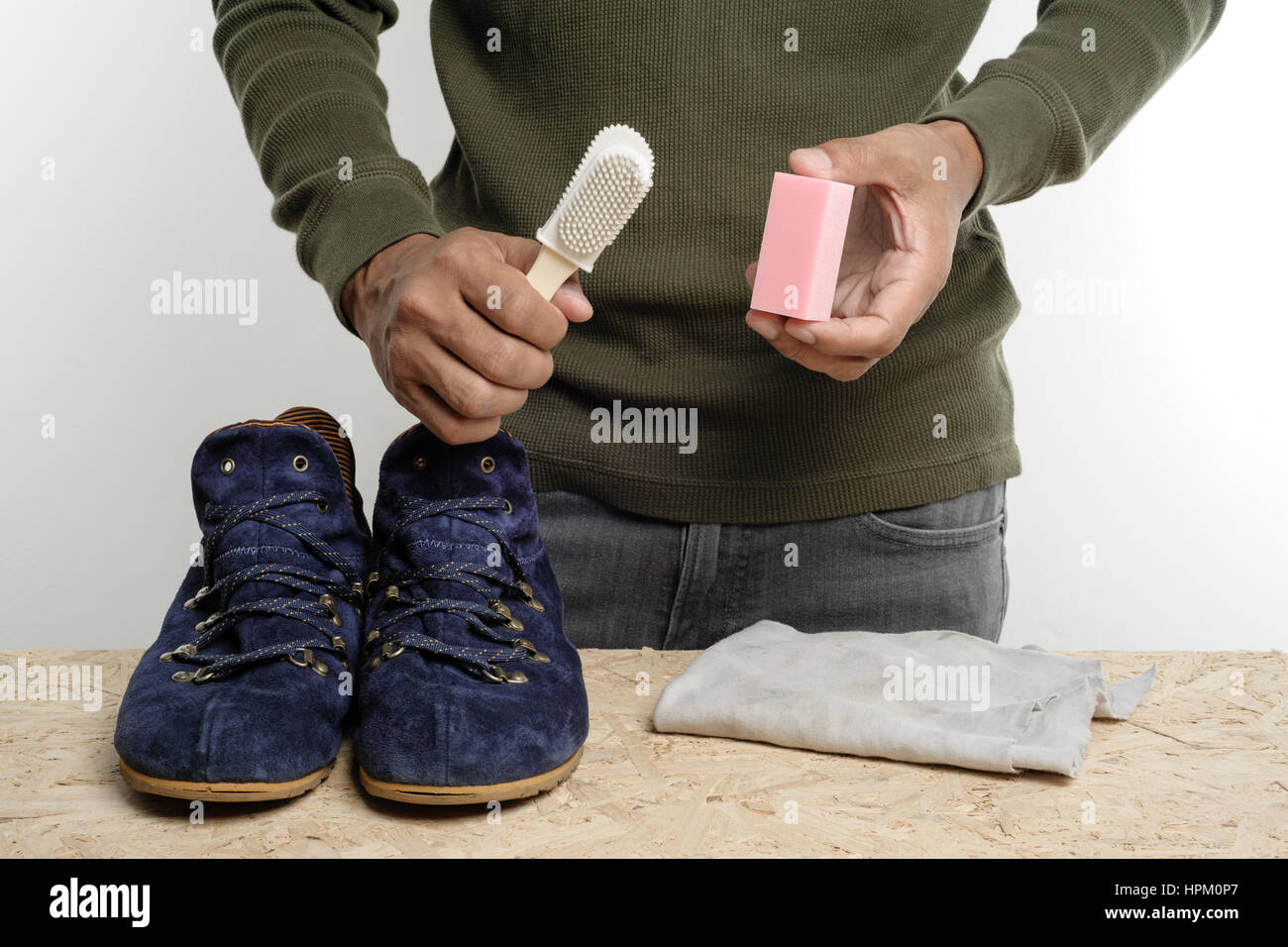 L'uomo la sua pulizia scarpe scamosciate, cura delle calzature Foto Stock
