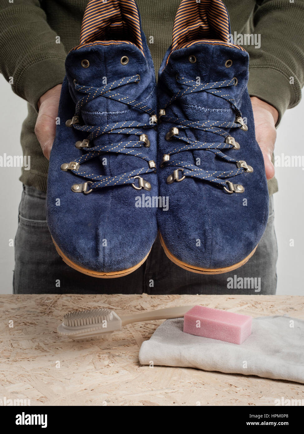 L'uomo la sua pulizia scarpe scamosciate, cura delle calzature Foto Stock