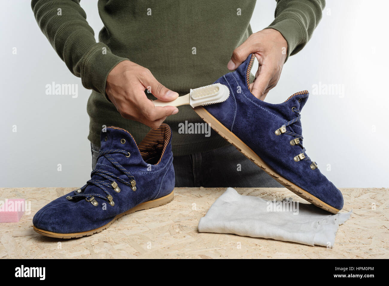 L'uomo la sua pulizia scarpe scamosciate, cura delle calzature Foto Stock