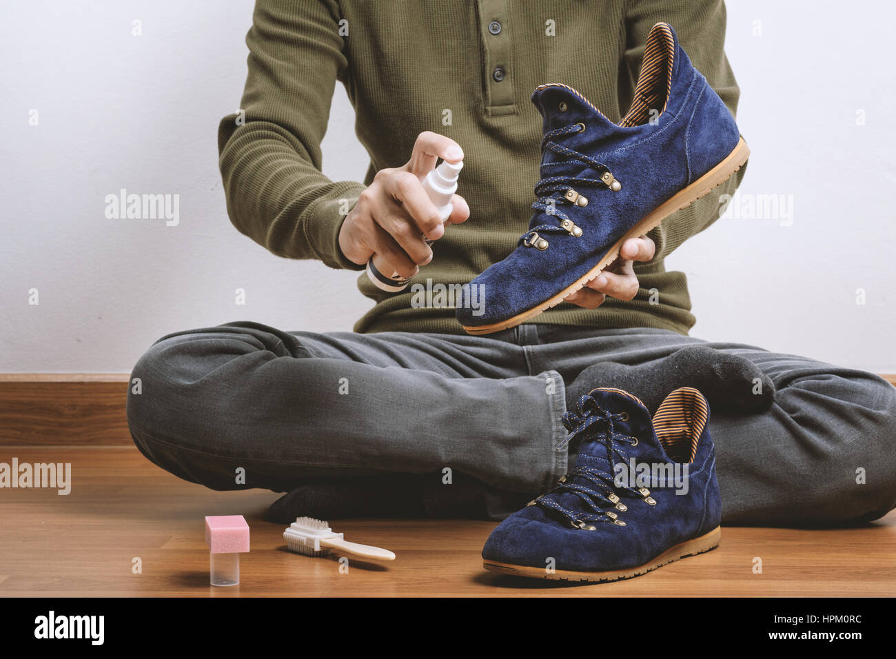 L'uomo la sua pulizia scarpe scamosciate, cura delle calzature Foto Stock
