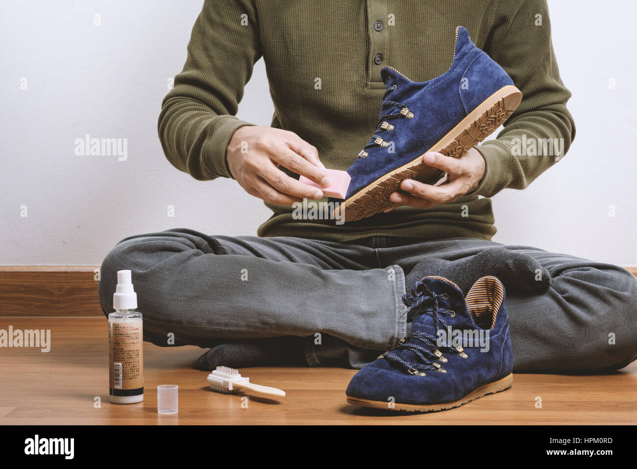 L'uomo la sua pulizia scarpe scamosciate, cura delle calzature Foto Stock