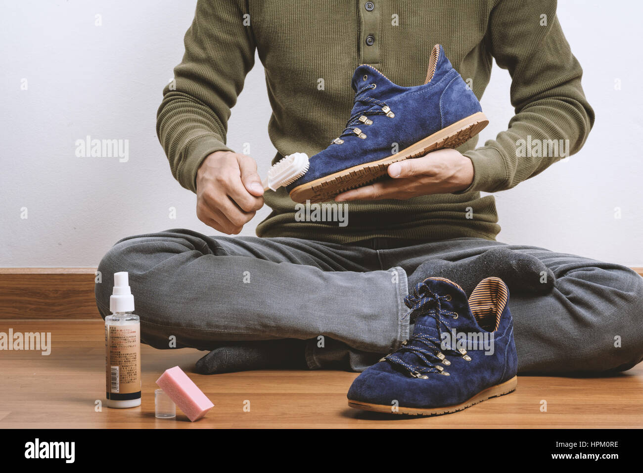 L'uomo la sua pulizia scarpe scamosciate, cura delle calzature Foto Stock