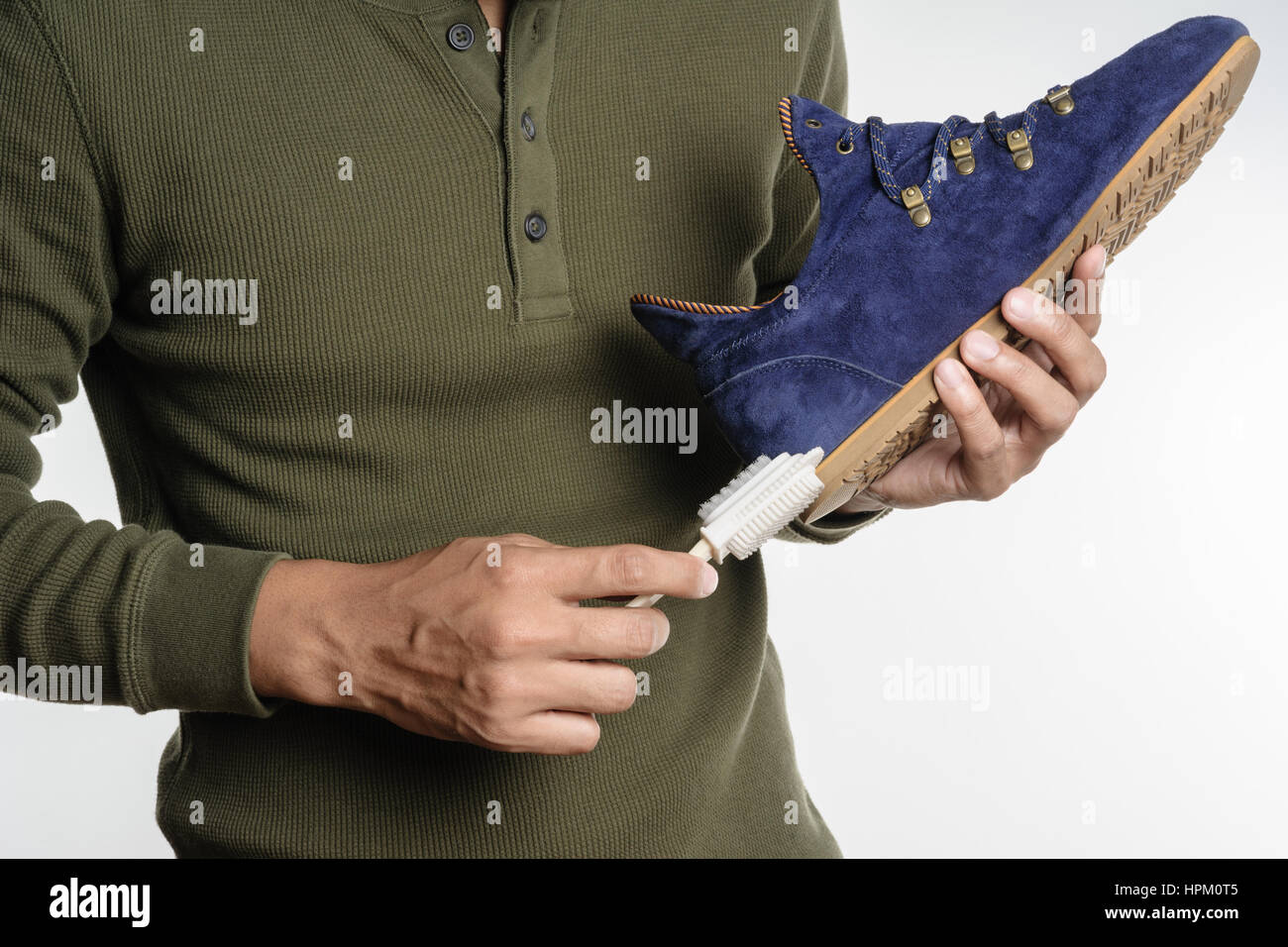 L'uomo la sua pulizia scarpe scamosciate, cura delle calzature Foto Stock