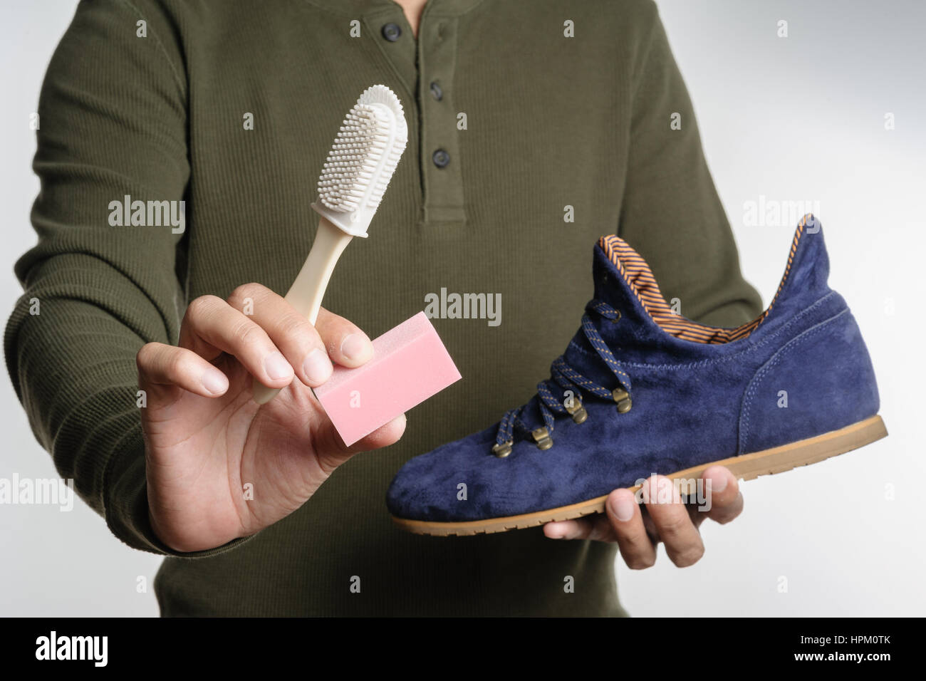 L'uomo la sua pulizia scarpe scamosciate, cura delle calzature Foto Stock