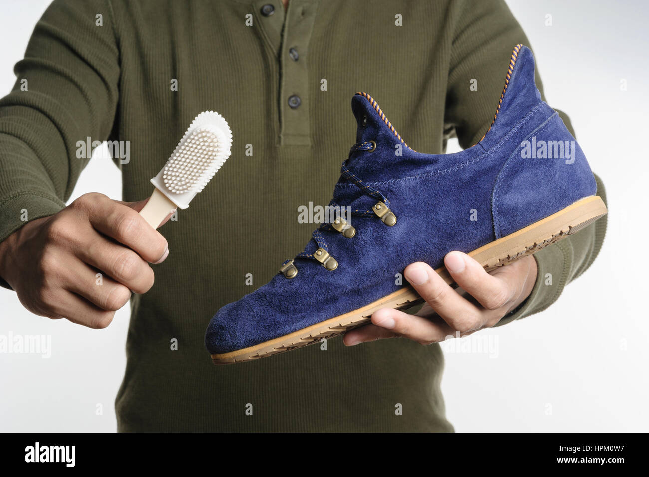 L'uomo la sua pulizia scarpe scamosciate, cura delle calzature Foto Stock