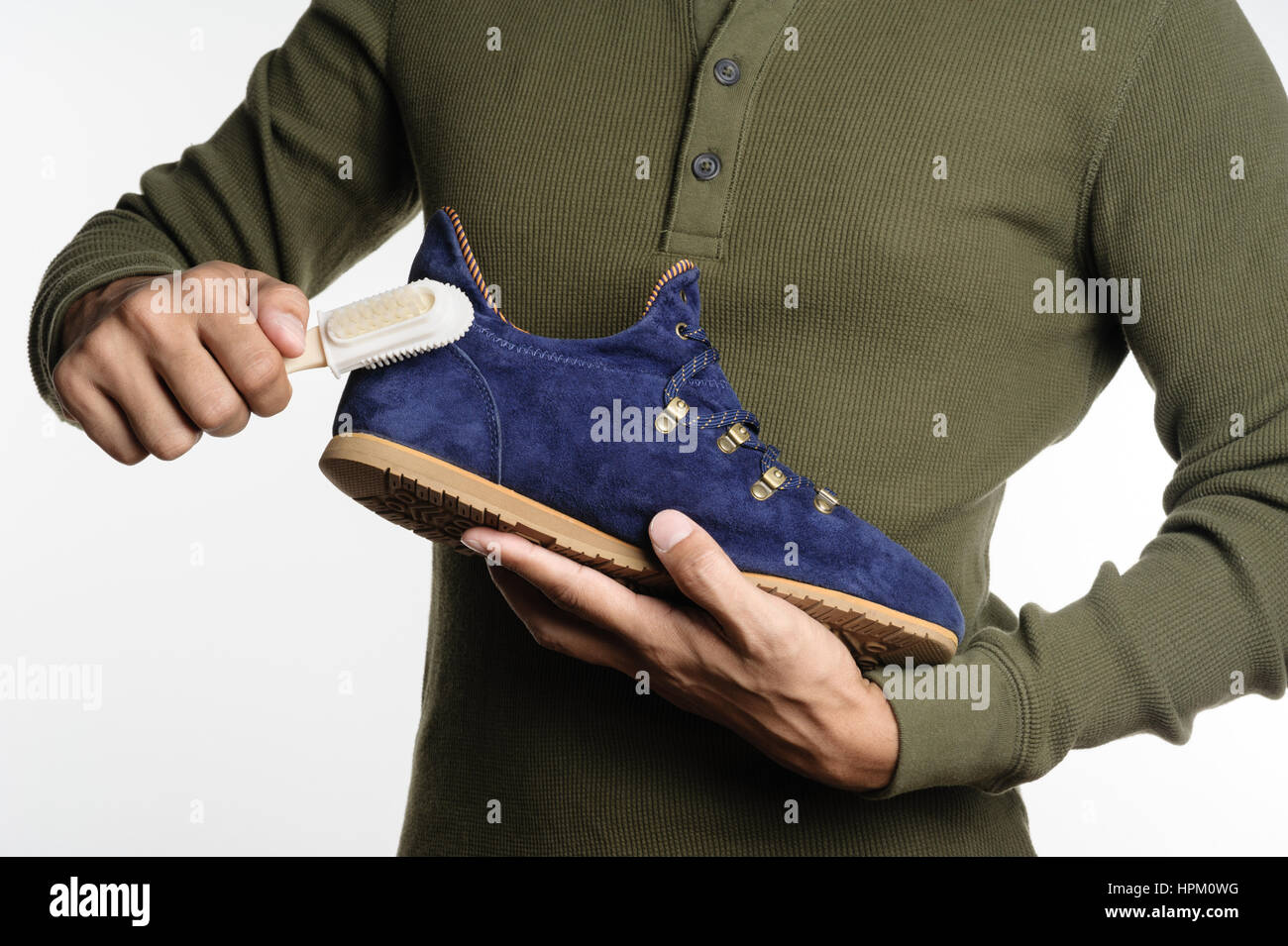 L'uomo la sua pulizia scarpe scamosciate, cura delle calzature Foto Stock