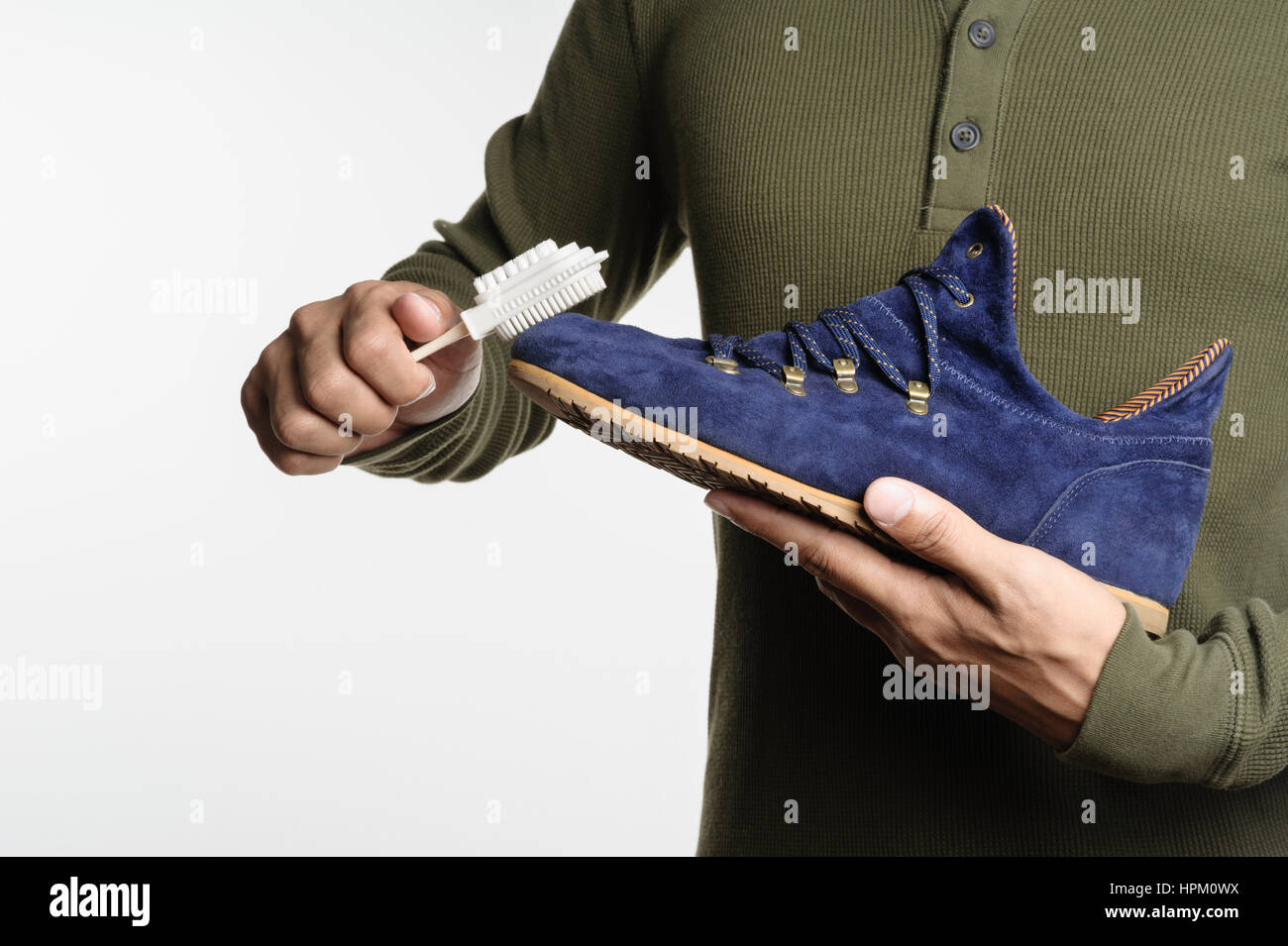 L'uomo la sua pulizia scarpe scamosciate, cura delle calzature Foto Stock