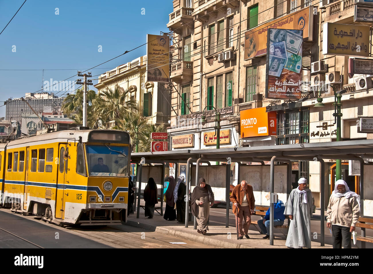 Alessandria street scene che mostrano il tram giallo, segni arabi e musulmani in attesa presso la stazione del tram Foto Stock