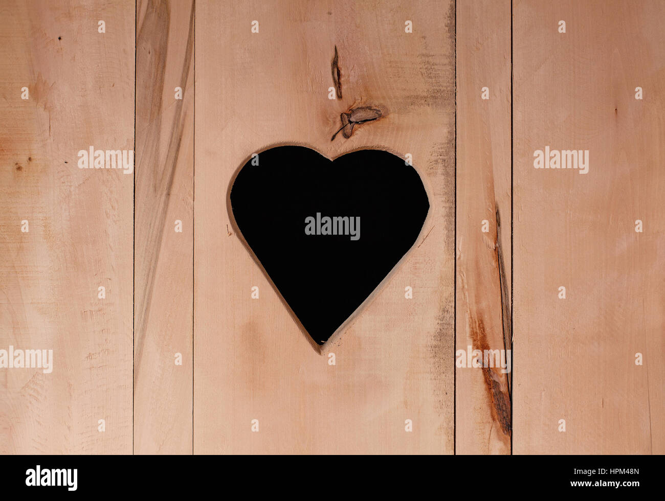 Vista ingrandita della superficie in legno con foro nella forma di Hart. Foto Stock