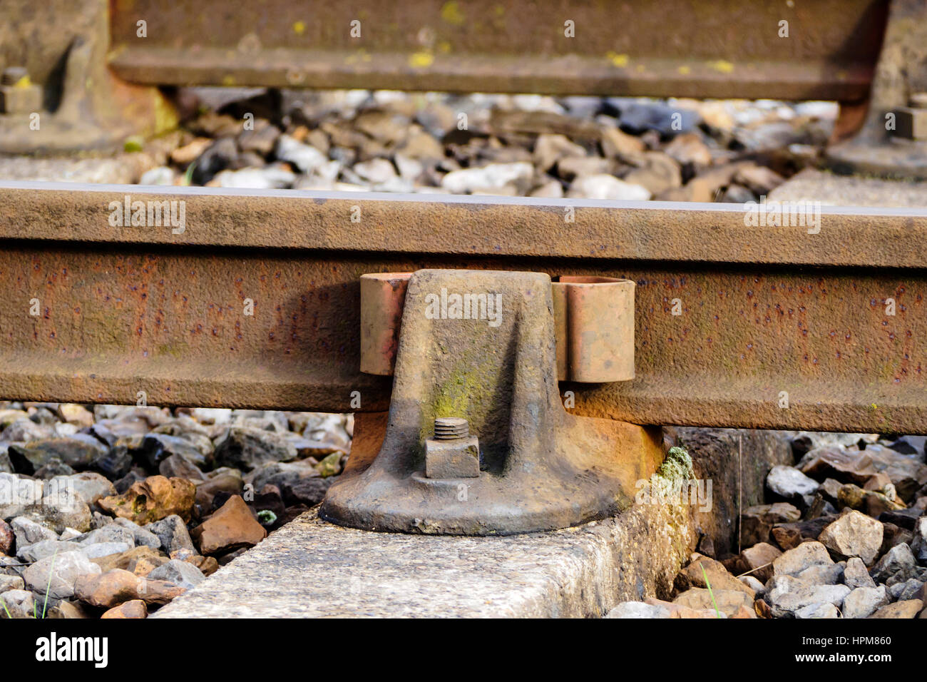 Un vecchio stile presieduto il binario ferroviario con paratia rampa e traversine di cemento con pietre di zavorra. Foto Stock