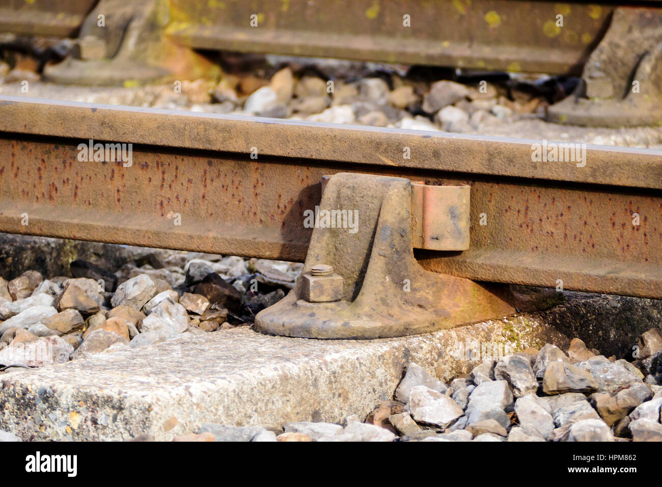 Un vecchio stile presieduto il binario ferroviario con paratia rampa e traversine di cemento con pietre di zavorra. Foto Stock