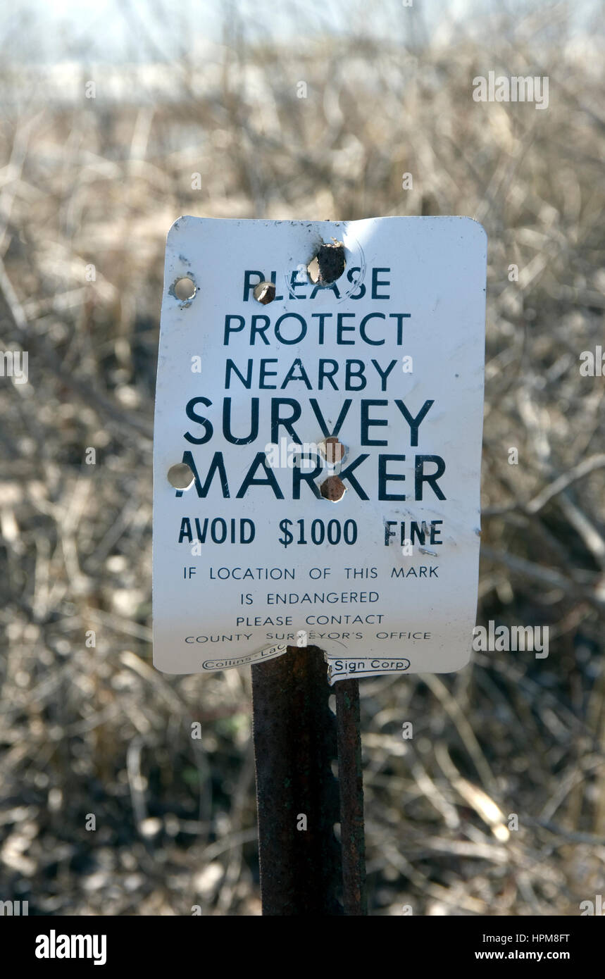 Sondaggio segno del marcatore di vandalismo da cacciatori, riddled con fori di proiettile Foto Stock