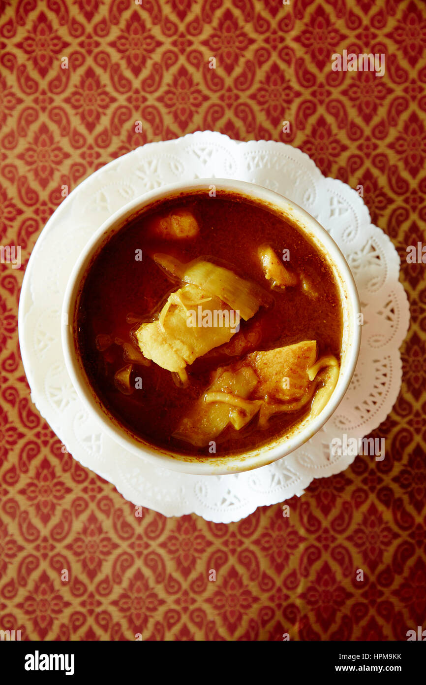 Kaeng Leuang - piccante di curcuma lime curry con pesce gatto, ananas, papaya, e gloria di mattina Foto Stock