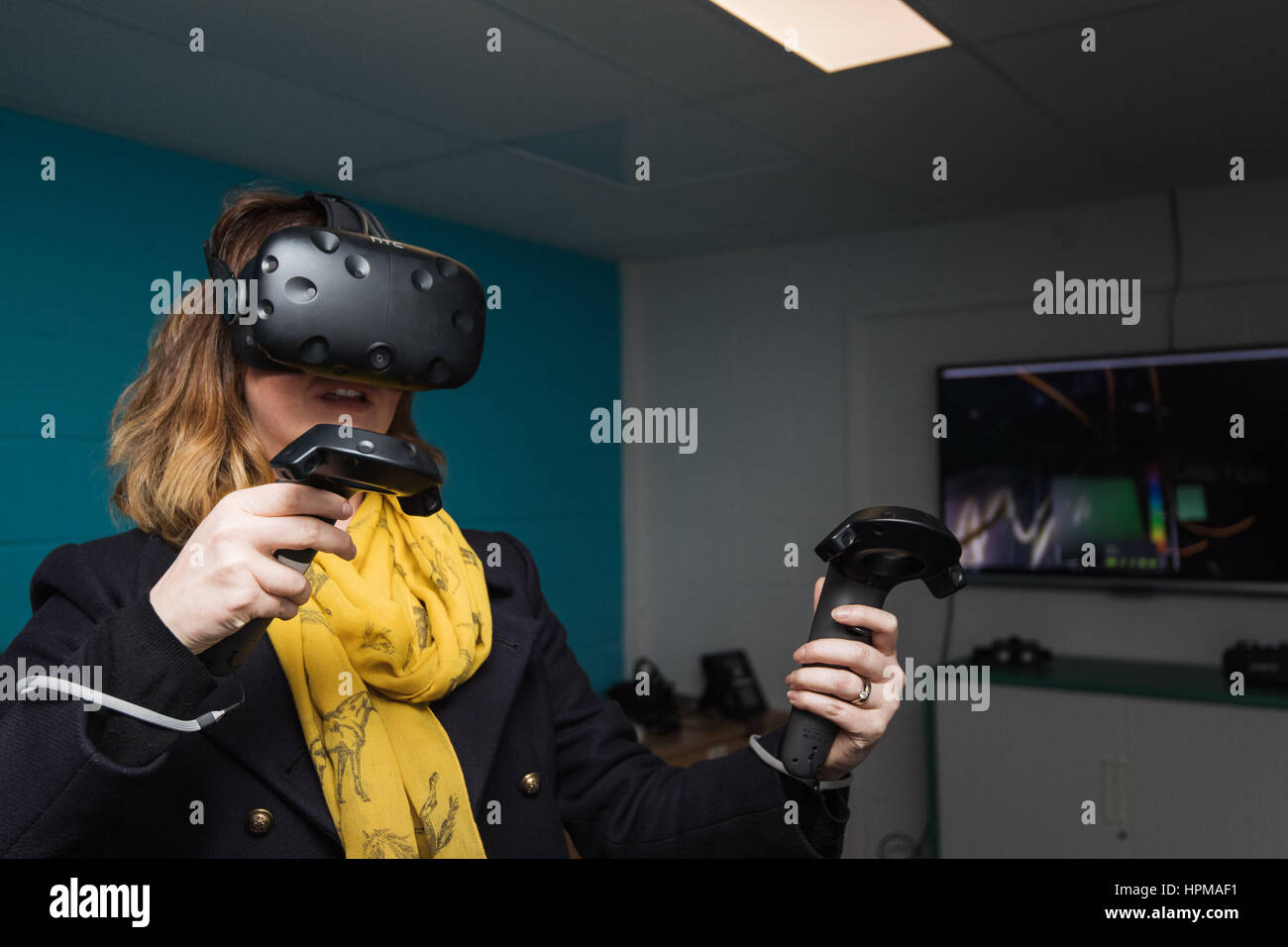 Una donna con una realtà virtuale o cuffia VR Foto Stock