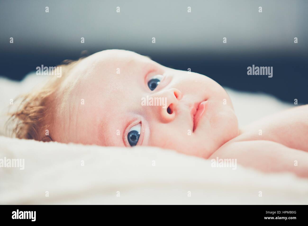 Ritratto di Allegro bambino con gli occhi blu nel letto. Foto Stock