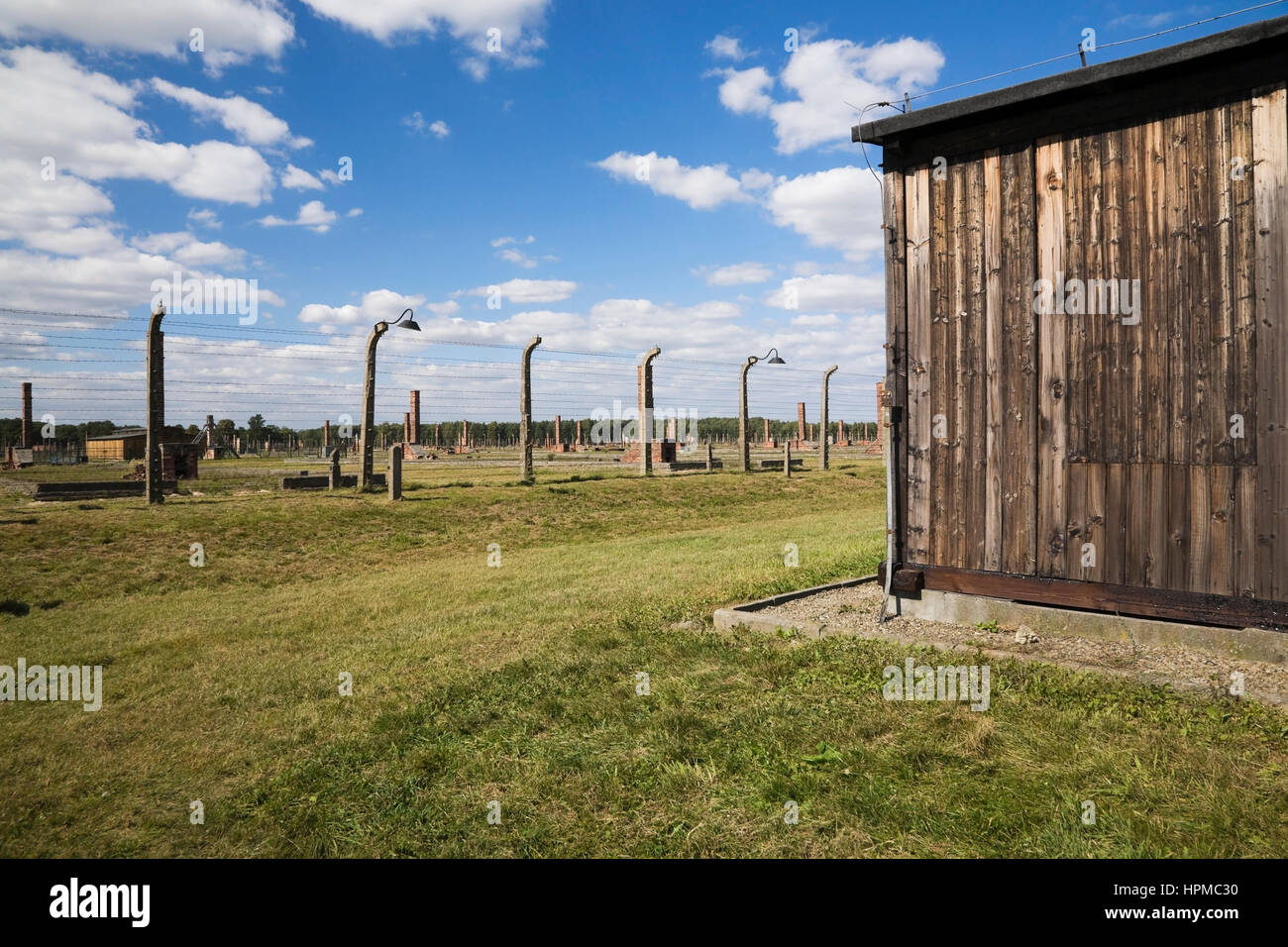 Edificio del dormitorio e filo spinato recinto elettrico ad Auschwitz II-Birkenau ex campo di concentramento nazista, Auschwitz-Birkenau, Polonia, Europa orientale Foto Stock